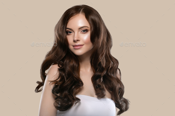 Beautiful hair skin woman portrait natural make up long curly hair. Color background brown