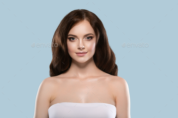 Beautiful hair skin woman portrait natural make up long curly hair. Color background blue