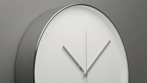 Chrome Clock Face on Dark Grey Office Wall