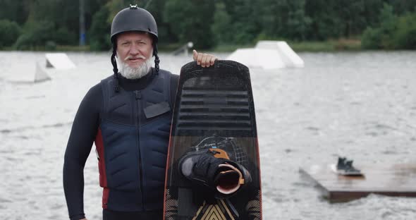 Wakeboarder, Portrait of Adult Man, Sportsman Stands Near the Lake, Looks at the Camera and Holds a alt