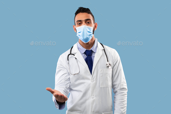 Arabic Doctor Wearing Mask Stretching Hand To Camera, Blue Background