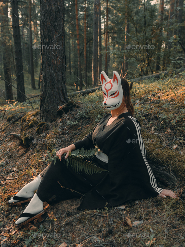 Woman wearing wolf mask standing in nature