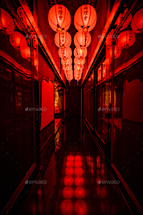 Lit red lanterns in a dark corridor
