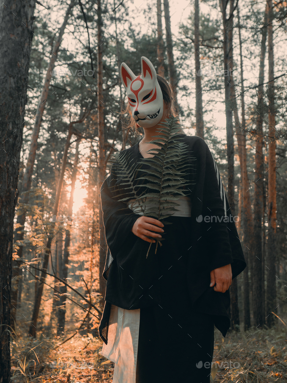 Woman wearing wolf mask standing in nature