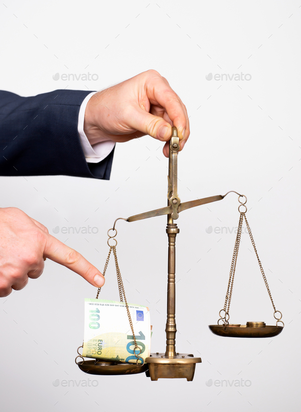 Money weighing on justice scale in business man hand. Payment balance and tax - Stock Photo - Images