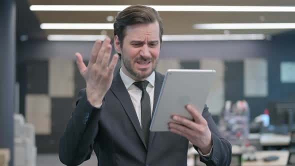 Portrait of Businessman Having Loss on Tablet in Office alt