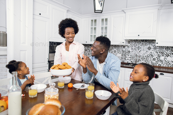 African family eating cookies and drinking juice on kitchen