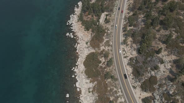 Aerial cinematic view mountain lake road. Road along mountains and lake.