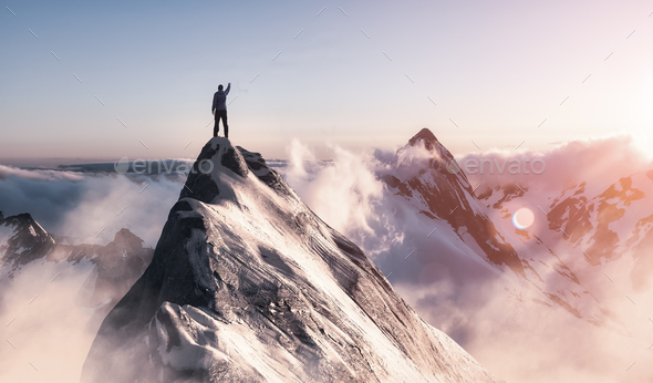 Adventurous Man is taking in the moment on top of a mountain