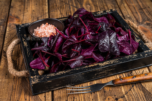 Fresh raw Swiss Ruby or red chard salad Leafs in a wooden tray. wooden background. Top view