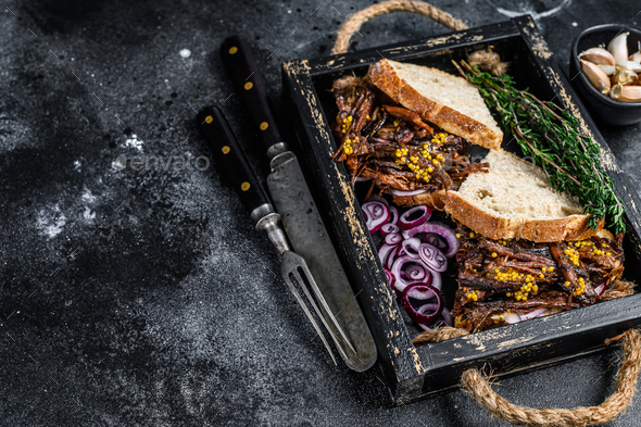 Pulled pork Sandwich with smoked pork meat in a wooden tray. Black background. Top view. Copy space