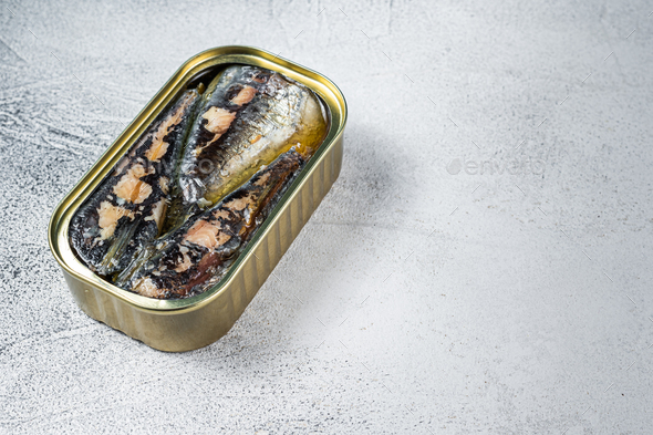 Open can with sardine in olive oil. White background. Top view. Copy space