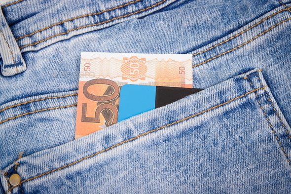 Currencies euro and credit card in blue jeans pocket. Choice between cashless or cash payment