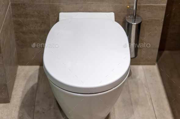Modern toilet interior design, hanging toilet bowl and brush, tiled