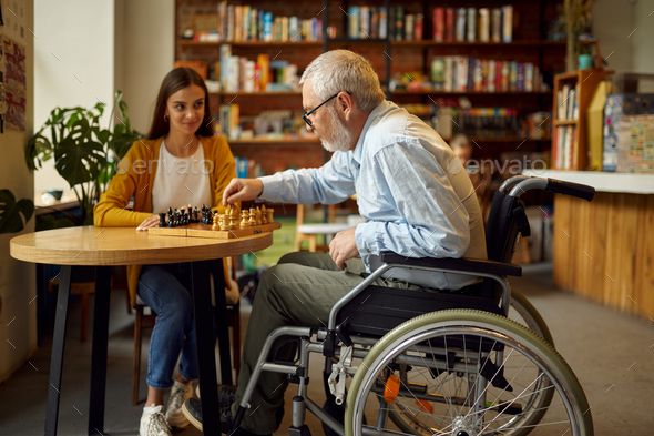 Disabled grandfather and granddaughter play chess