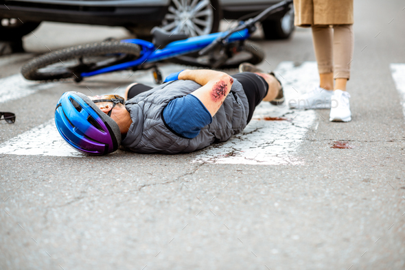 Road accident with injured cyclist and car