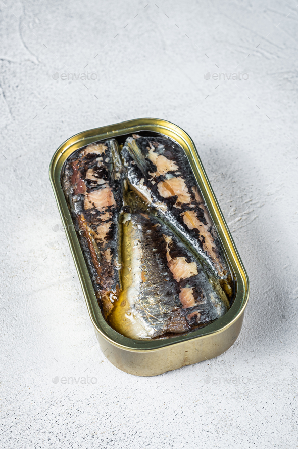 Open can with sardine in olive oil. White background. Top view