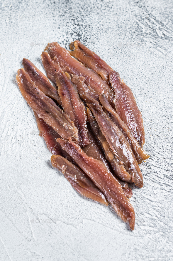 Canned Anchovies fish fillet in Olive Oil. White background. Top view