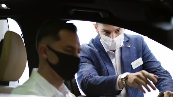 Salesman Presenting Executive Class Car to a Man Inside of Show Room alt