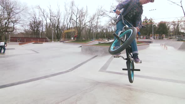 BMX Rider Doing Tricks in Cocncrete Skatepark alt