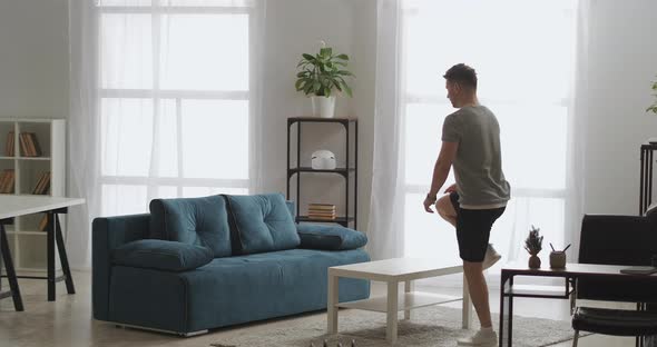 Sport in Apartment Adult Athletic Man Is Using Table Like Sporty Equipment Lifting on It and alt