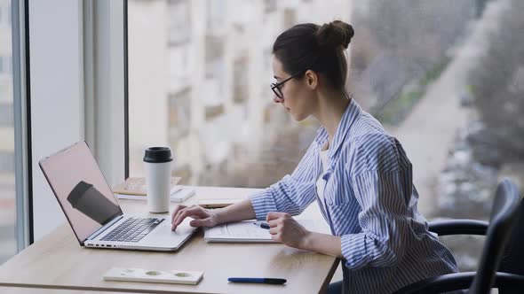 Woman Working in Office with Panoramic Window