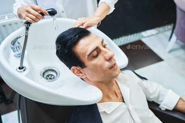 Beautician washing man hair in wash sink Stock Photo by Iakobchuk |  PhotoDune
