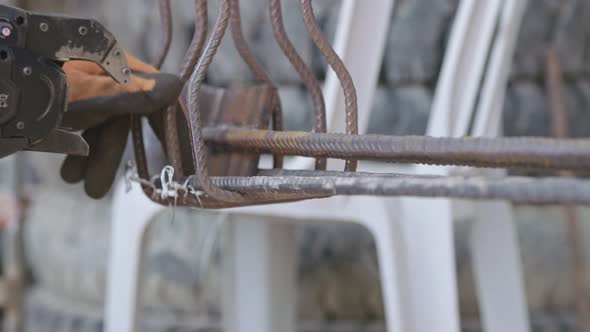 Steel fixers connecting steel rods for concrete reinforcement alt