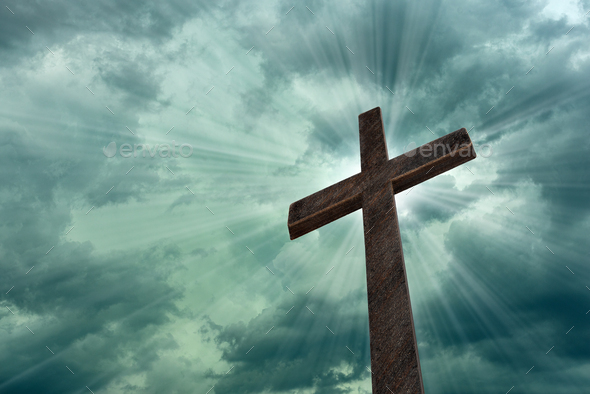 Religious cross against light rays and parting clouds - Stock Photo - Images