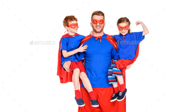 happy super father holding smiling kids in masks and cloaks isolated on white