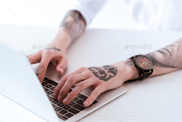cropped image of tattooed businessman working with laptop Stock Photo by  LightFieldStudios