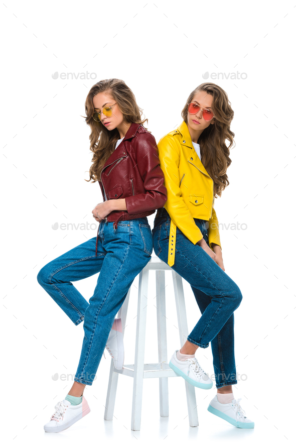 attractive stylish twins in leather jackets and sunglasses sitting on