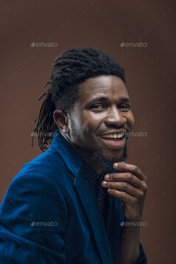 smiling african american man touching beard isolated on brown Stock ...