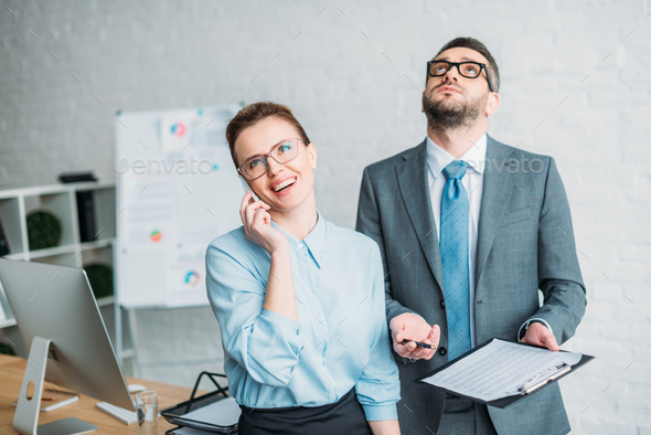 businessman asking his colleague to sign contract while she talking by phone and annoying him