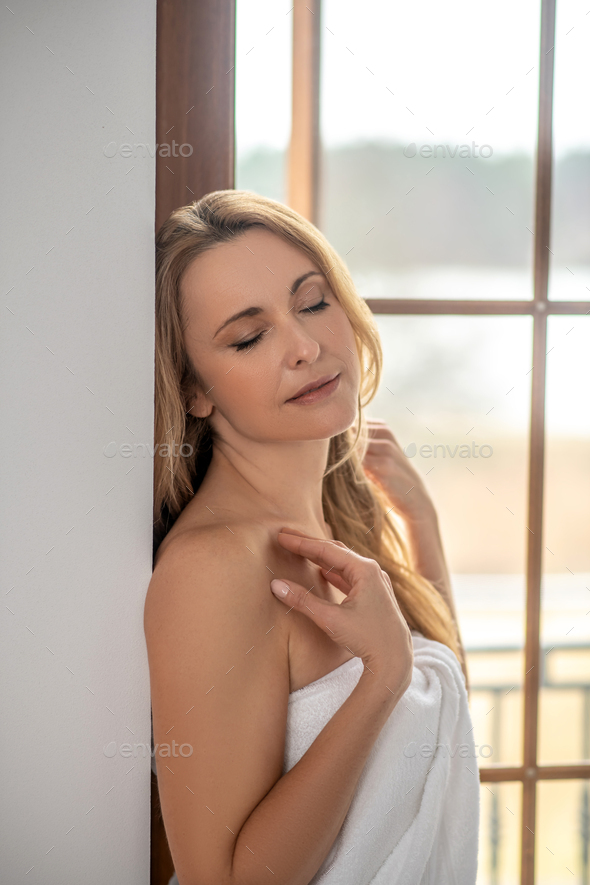 Blonde woman with closed eyes and bare shoulders