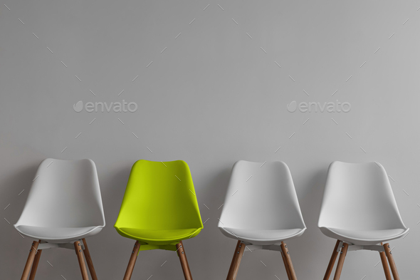 Three vacant white chairs and yellow on gray wall background in office or living room