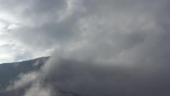 Heavy mist above the mountain top by winter 4K drone footage alt