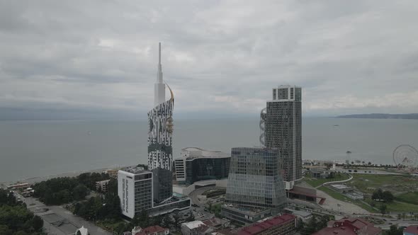 Aerial shot of alphabetic tower, skyscrapers and embankment of beautiful city of Batumi, Georgia alt