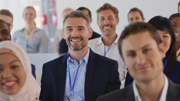 Audience at a seminar raising hands to ask questions alt
