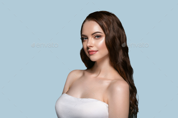 Beautiful hair skin woman portrait natural make up long curly hair. Color background blue