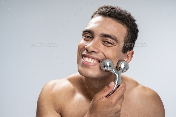 Cheerful man making his face look healthier - Stock Photo - Images