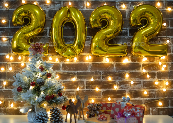 Merry Christmas And Happy New Year, Small Christmas Tree On Table, 2022 In Golden Inflatable Numbers Stock Photo By Lucigerma