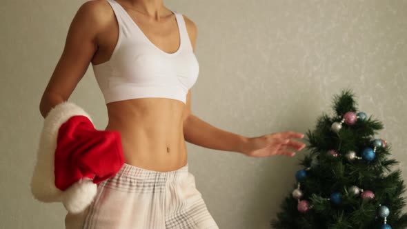 Close up of perfect athletic fitness woman body with Christmas hat