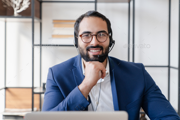 Front view portrait of a video call of Middle Eastern businessman IT support hot line worker