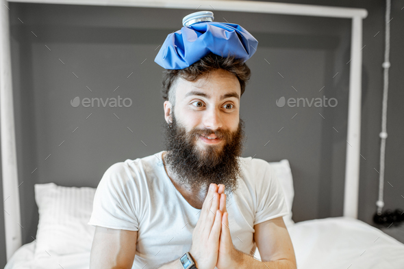 Man with ice bag in the bedroom