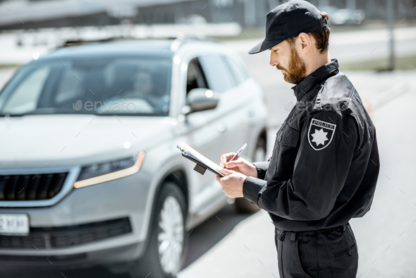 Policeman issuing a fine on the roadside Stock Photo by RossHelen ...