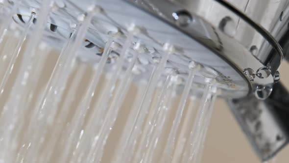 Close Up of Water Drops Flowing From Shower Head in Bathroom Slow Motion alt