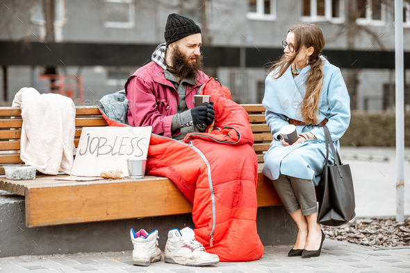Homeless beggar with young woman listening to his story