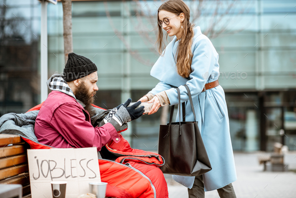 Woman giving food to a homeless beggar