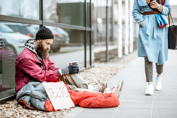 Homeless begging money to a passing by woman